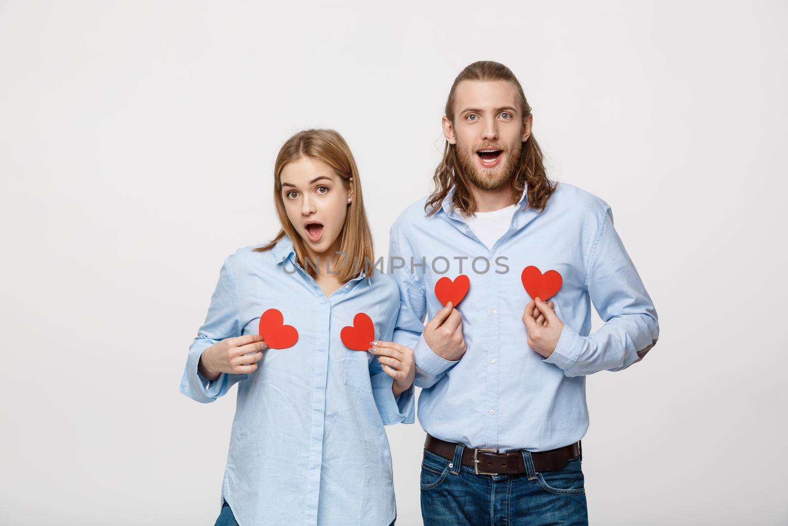 Couple in love holding red paper hearts.