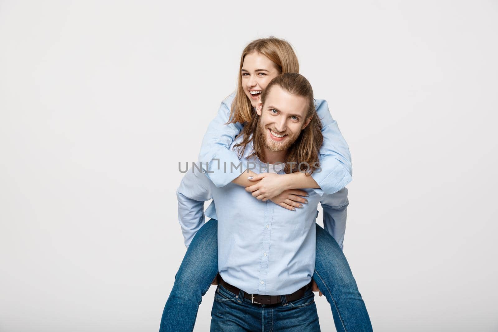 Portrait of smiling man giving happy woman a piggyback ride