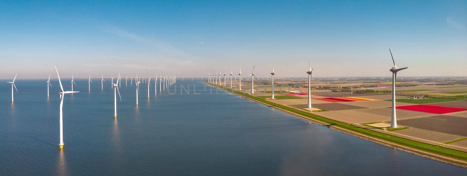 Windmill farm in the ocean Westermeerwind park, windmills isolated at sea on a beautiful bright day Netherlands Flevoland Noordoostpolder. Huge windmill turbines