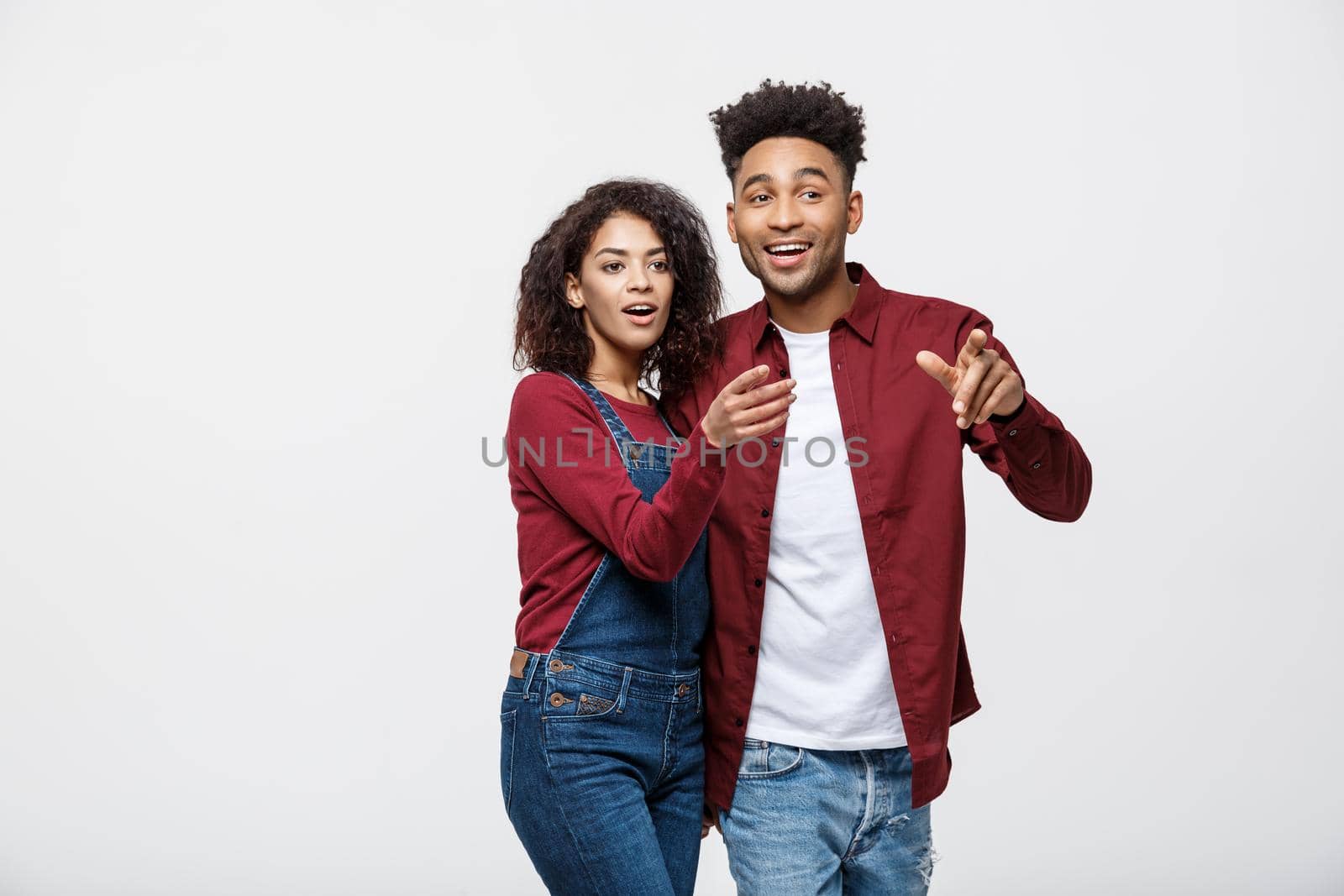 Young African American people in casual clothes looking away and point finger. isolated on white background.