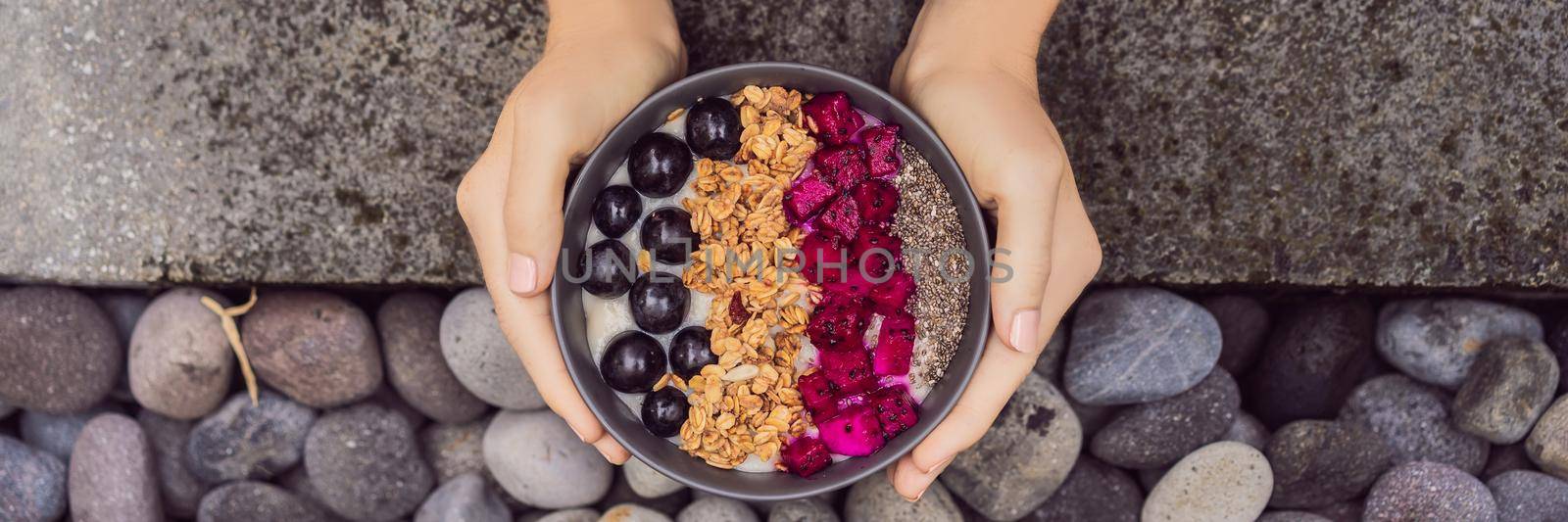 Girl relaxing and eating fruit Smoothie Bowl by the hotel pool. Exotic summer diet. Tropical beach lifestyle. BANNER, LONG FORMAT