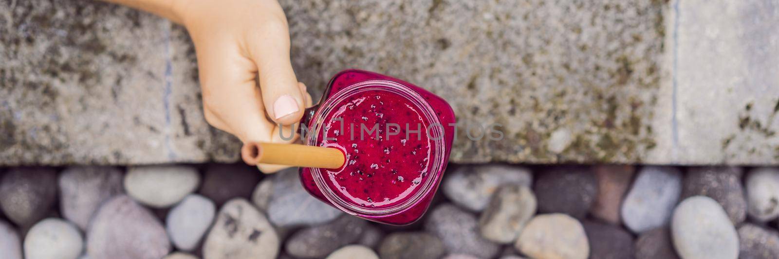 Young woman drinking Dragon fruit smoothies on the background of the pool. Fruit smoothie - healthy eating concept. Close up of detox smoothie with Dragon fruit BANNER, LONG FORMAT by galitskaya