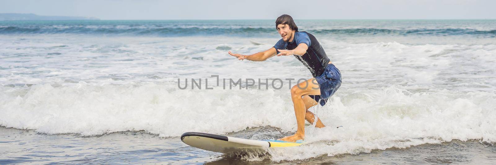 BANNER, LONG FORMAT Surfer on the wave, catches a wave, surfing in the pipe. Surfing in the ocean on the island of Bali, a mellow man, a jump into the ocean. Taken from the water. Photographed from the water.