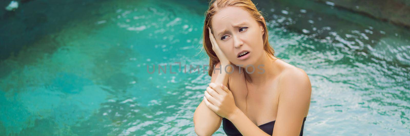 Woman has an ear ache in the pool. Diver ear. BANNER, LONG FORMAT