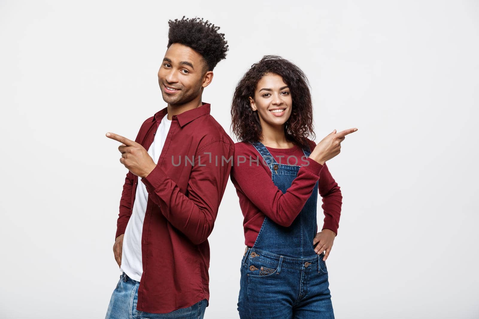 Young African American people in casual clothes looking away and point finger. isolated on white background.