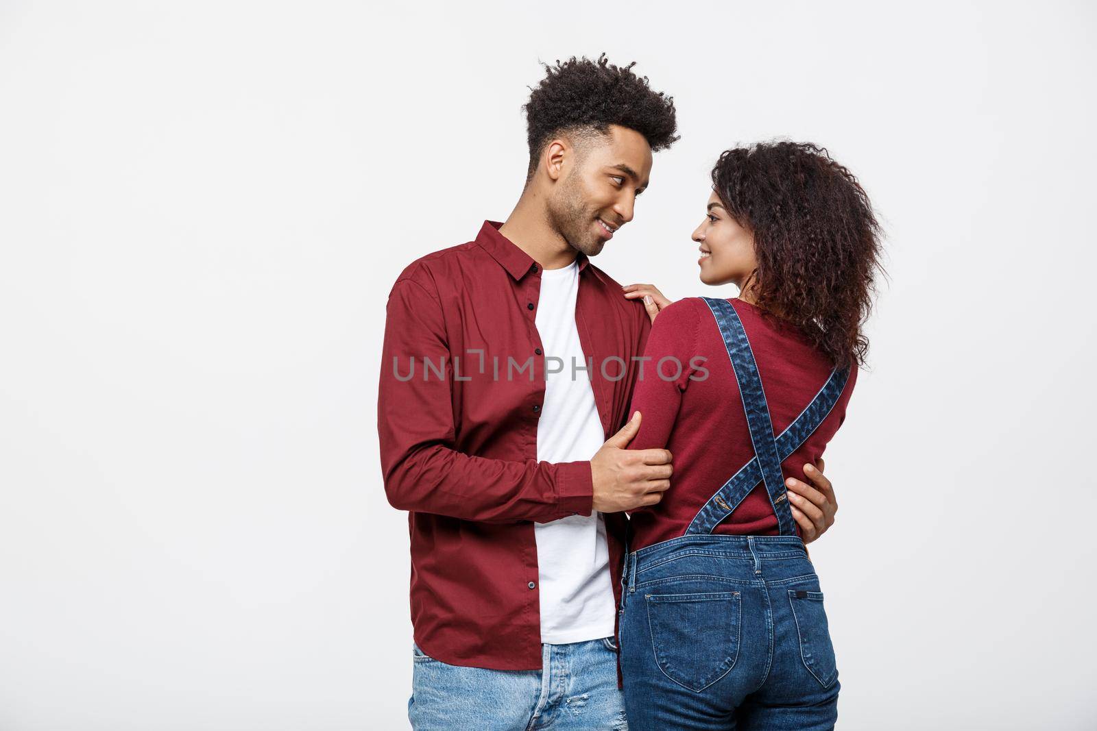 portrait of happy african american couple hug each other on white background