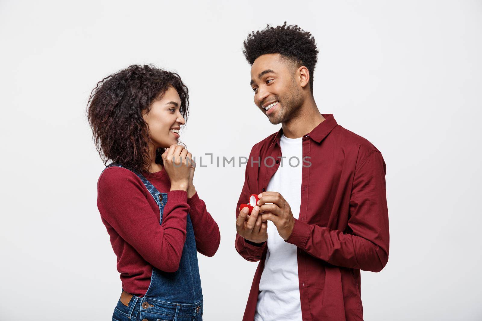 Young handsome african american man surprisingly ask her girlfriend for proposal by Benzoix