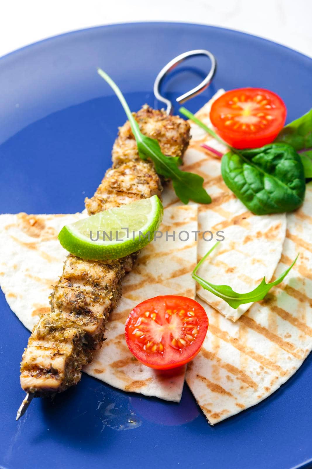 herbal meat skewer  with pita bread, tomatoes and lime by phbcz