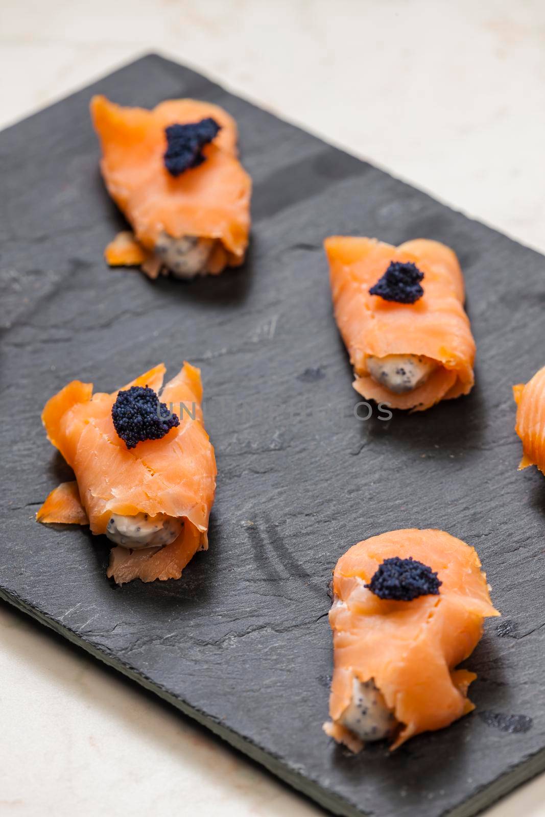 smoked salmon rolls filled with cream cheese and black caviar by phbcz