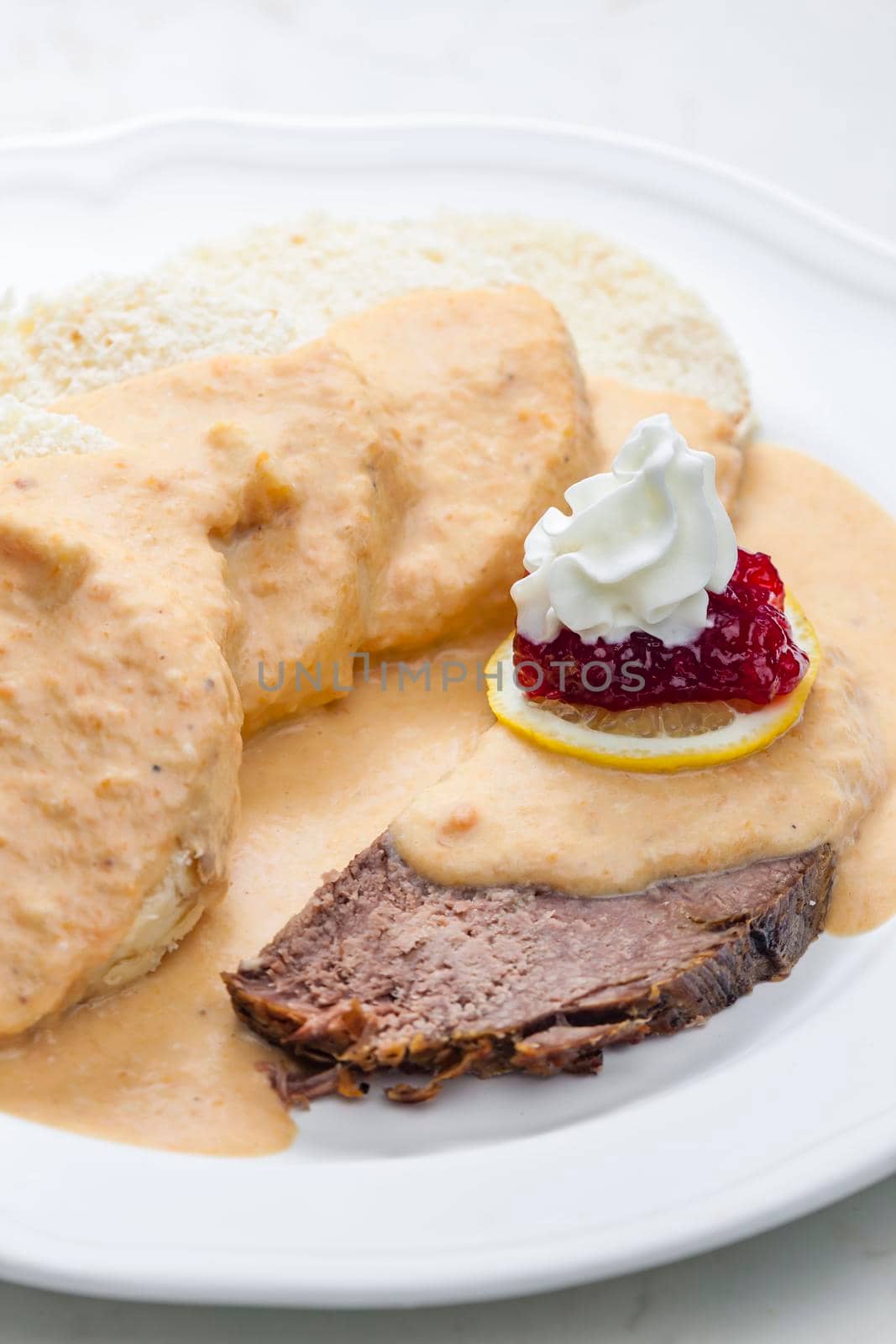 sirloin sauce with dumplings and cranberries on lemon with whipped cream by phbcz