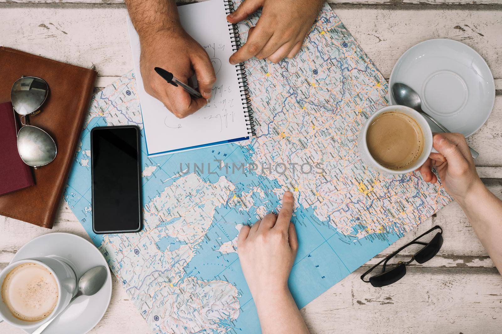 young couple choosing their holiday destination, using a map and writing down the route. young couple planning their honeymoon. trip, romantic