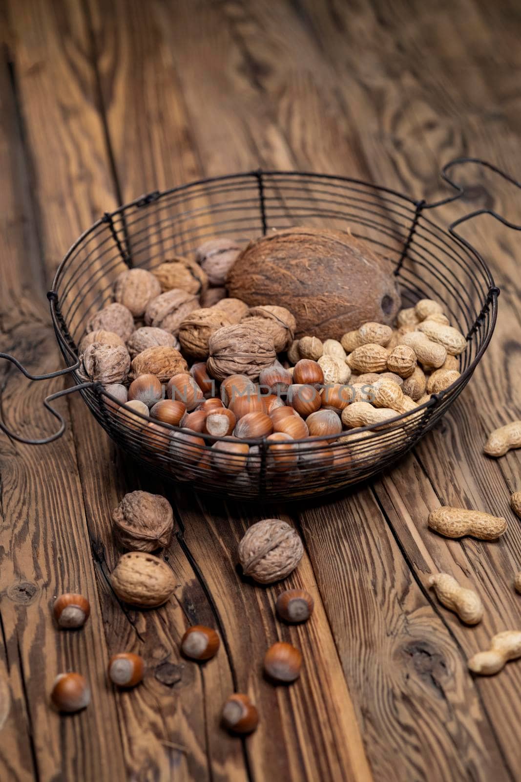 different kinds of nuts on a wooden background by phbcz