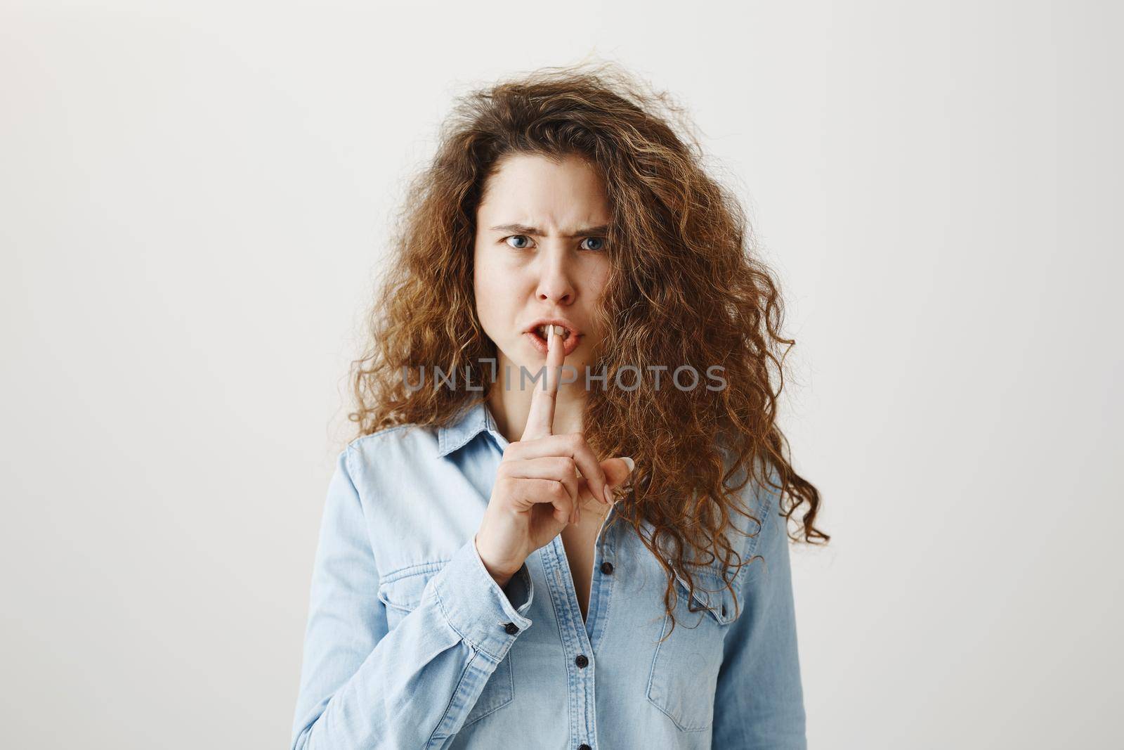 Close up portrait of cute lovely attractive uncertain unsure with entrepreneur making hush gesture isolated on gray background copy-space.