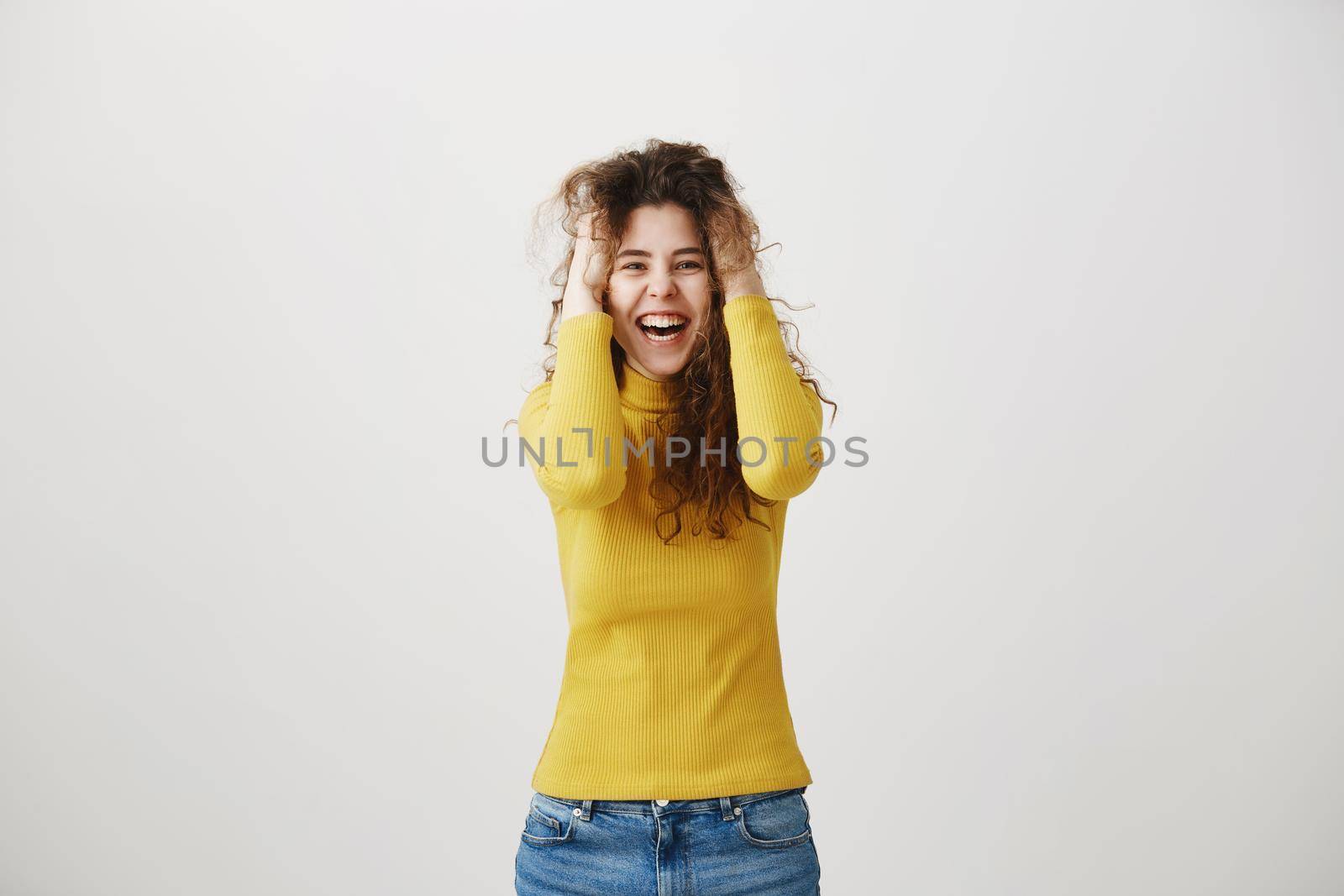 Portrait of beautiful cheerful redhead girl with curly hair smiling laughing looking at camera over white background