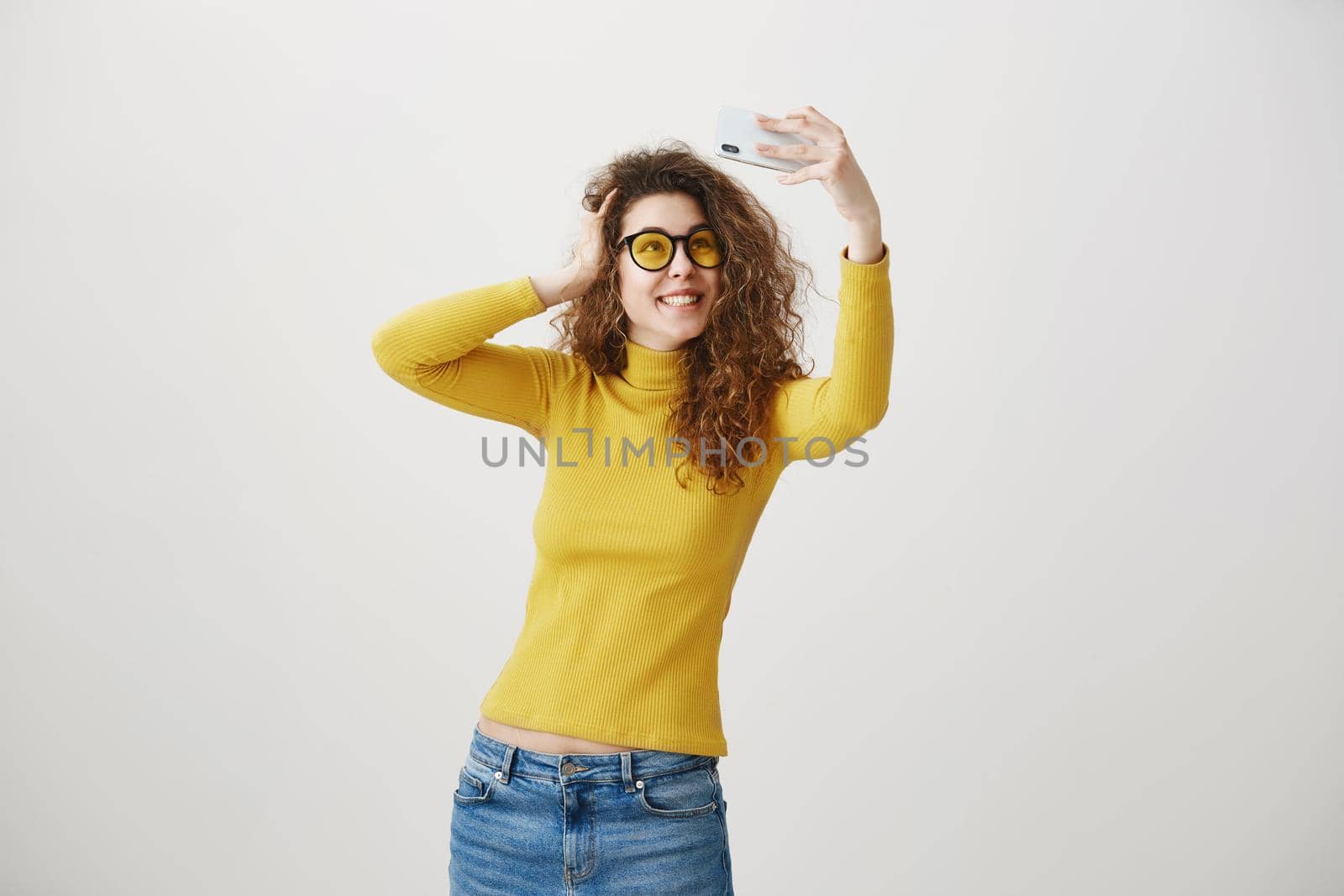 Charming stylish woman making selfie photo on smartphone isolated on a white background