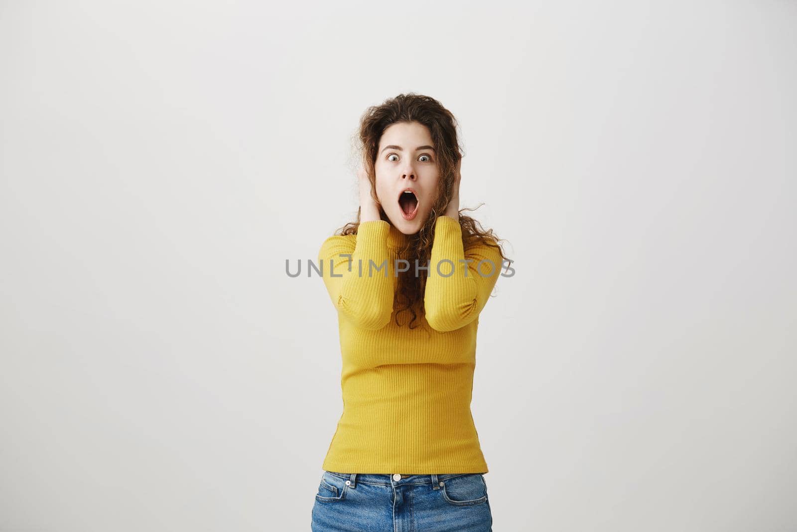 Portrait excited screaming young woman standing isolated over white background. Looking camera