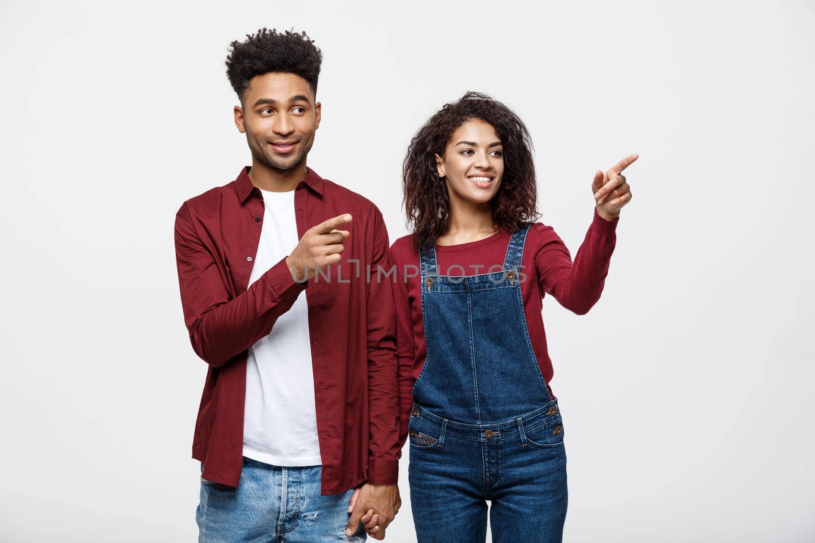 Young African American people in casual clothes looking away and point finger. isolated on white background.