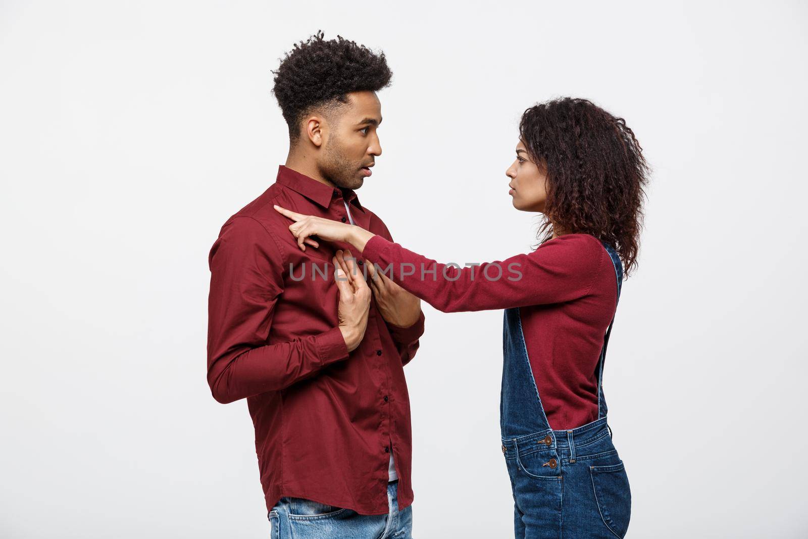 Unhappy African American couple in casual clothes arguing and figthing