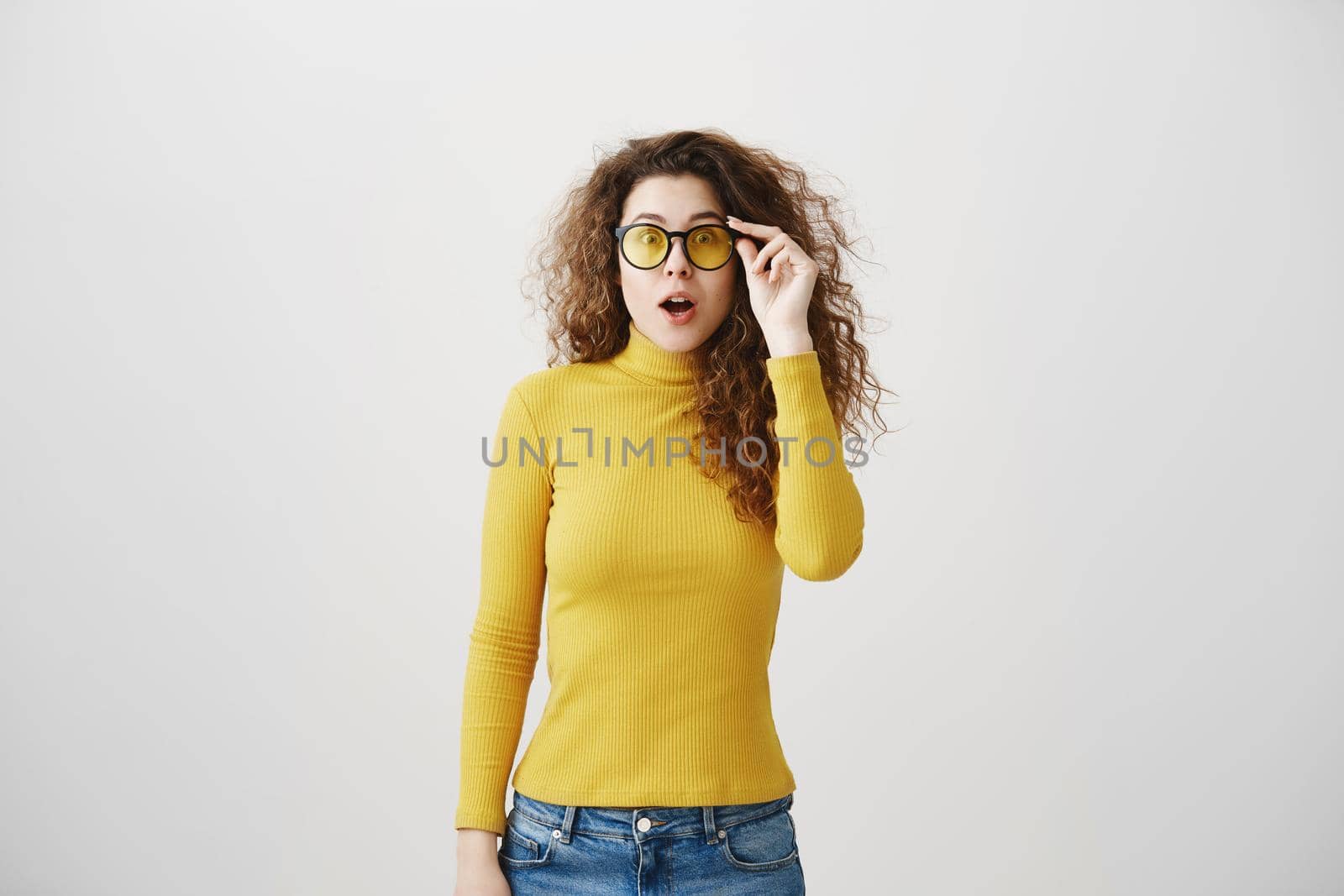 Portrait excited surprise young woman standing isolated over white background. Looking camera