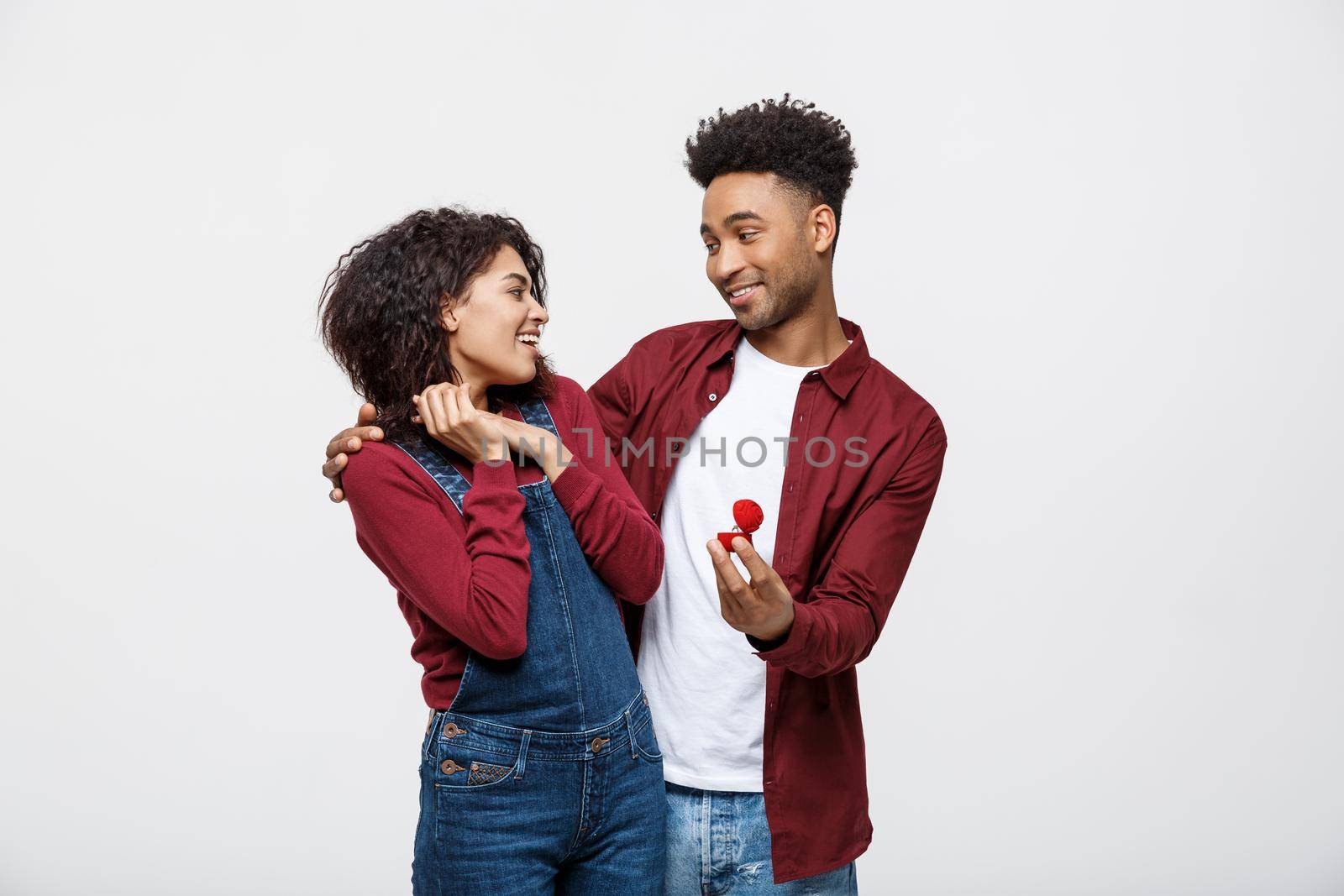 Young handsome african american man surprisingly ask her girlfriend for proposal by Benzoix