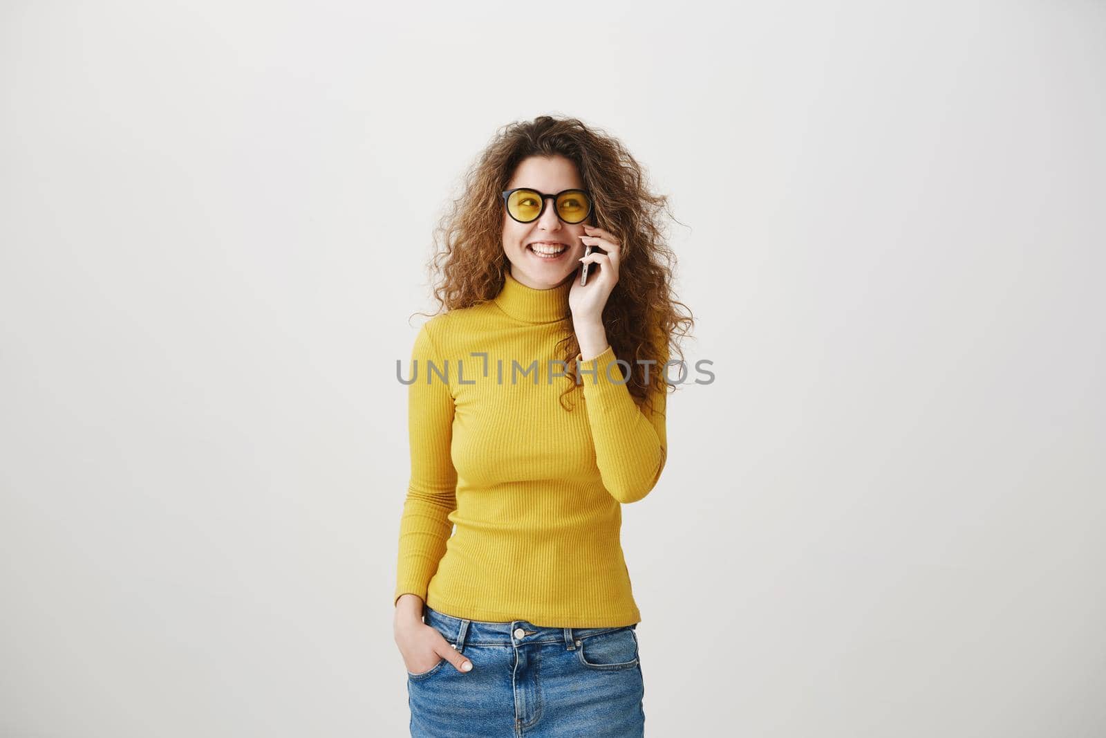 Cheerful young woman talking on mobile phone isolated on gray background