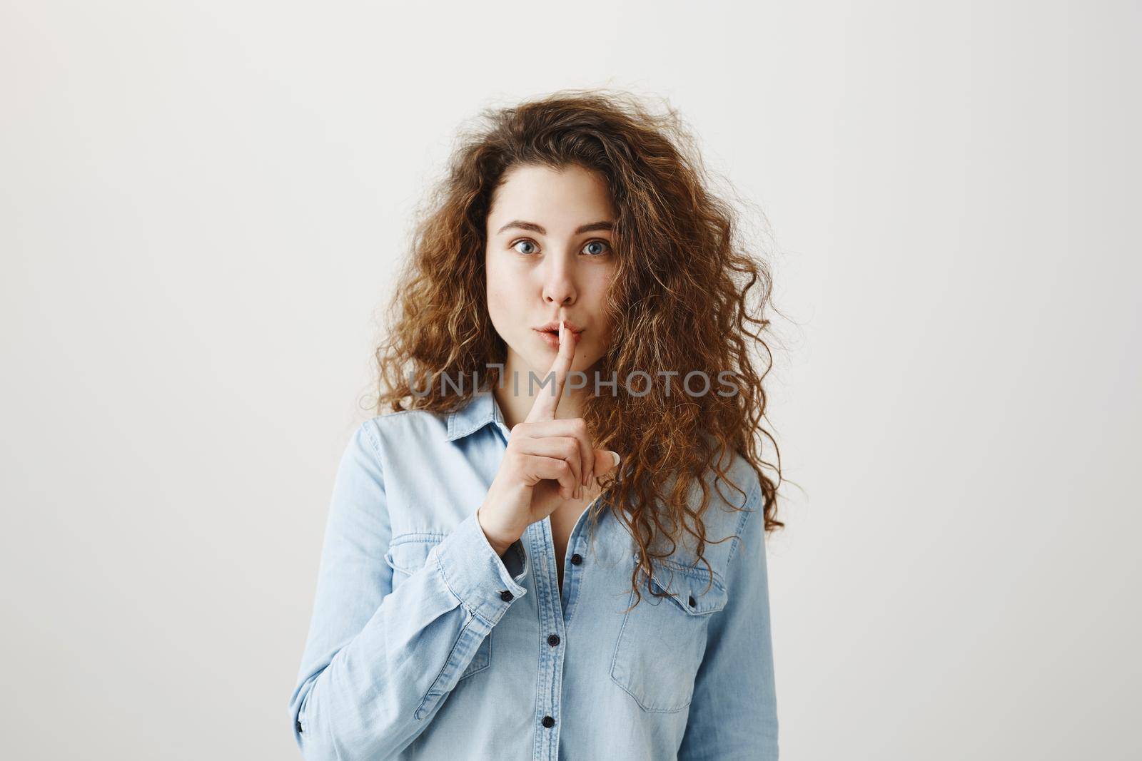 Close up portrait of cute lovely attractive uncertain unsure with entrepreneur making hush gesture isolated on gray background copy-space.