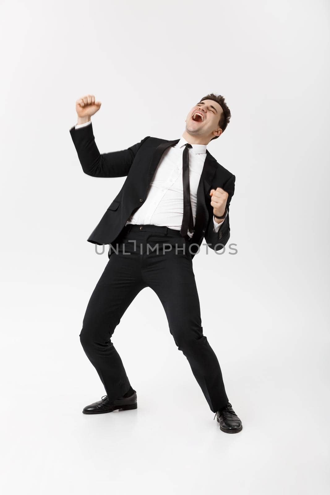 Business Concept - Handsome cheerful businessman showing hands in air over gray background