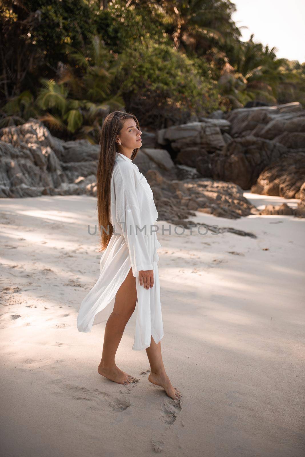 uropean young tan women have rest and run on white sand beach by AndriiDrachuk