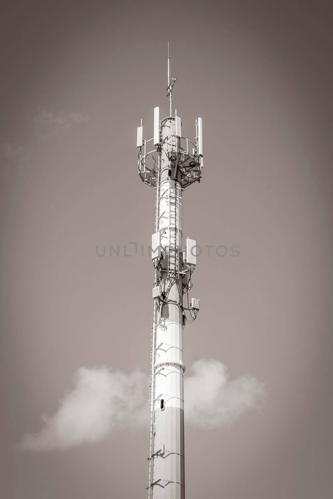 Old black and white picture Red white 5G tower with blue sky background radiation kills us in Playa del Carmen in Mexico.