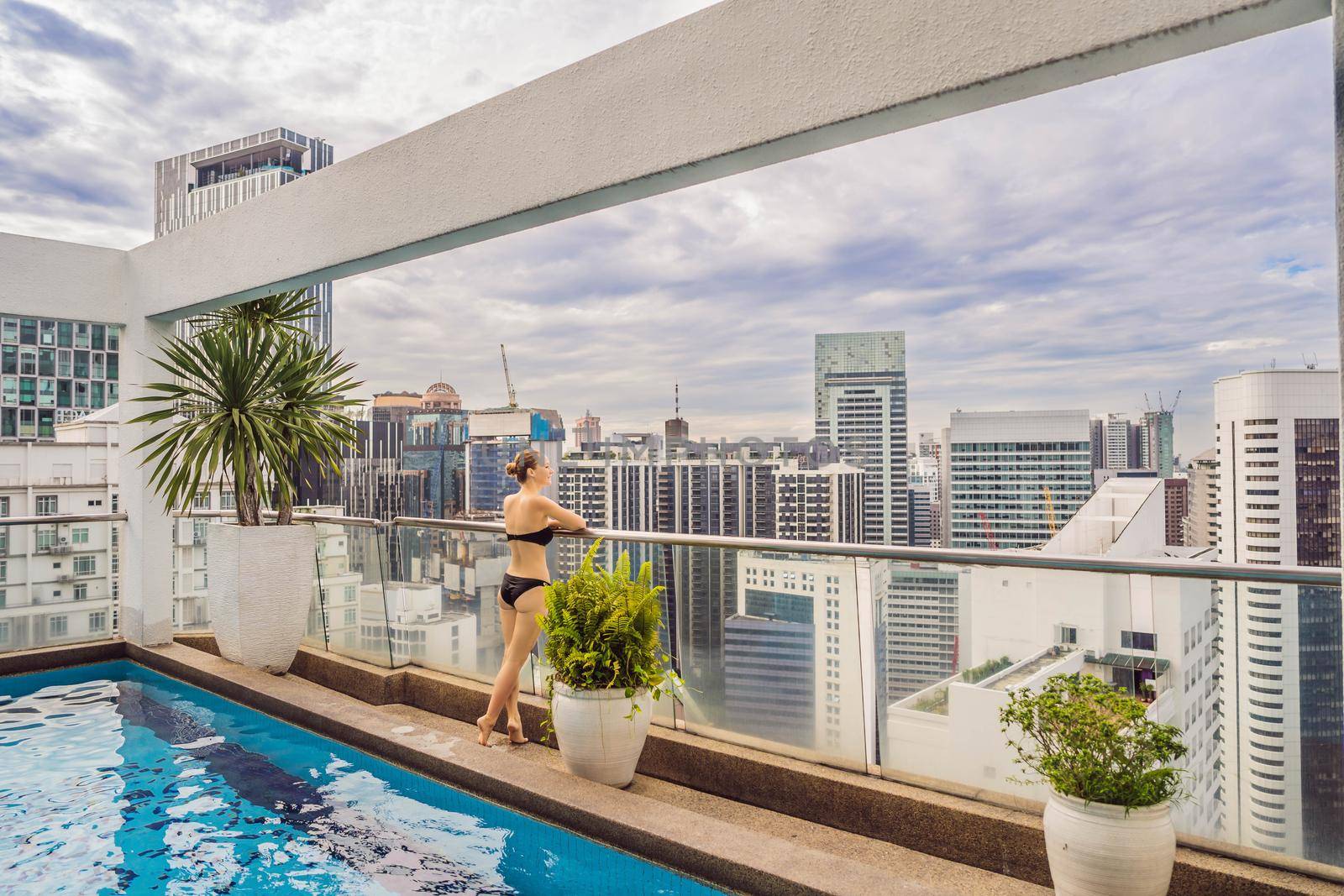 Malaysia, Kuala Lumpur November 21, 2018: Young woman in the pool among the skyscrapers and the big city. Relax in the big city. Rest from stress by galitskaya