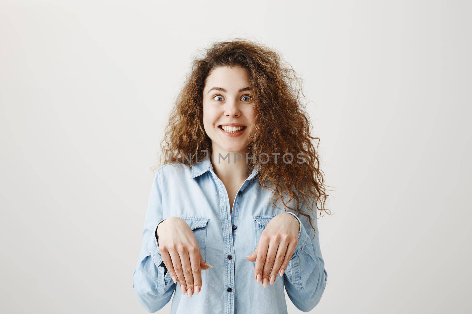 Funny girl showing bunny hands with her hands isolated on gray background.