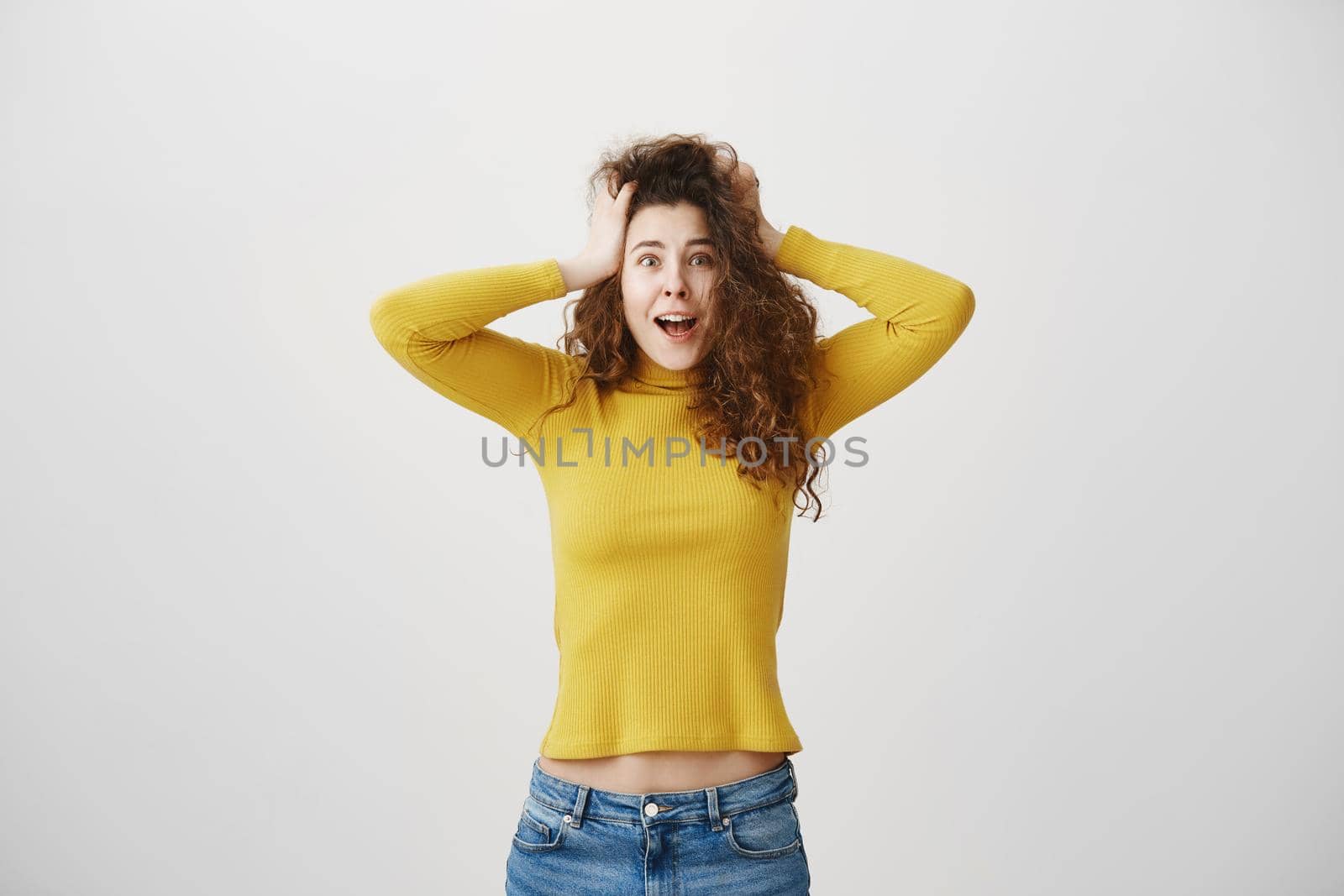 Portrait excited screaming young woman standing isolated over white background. Looking camera