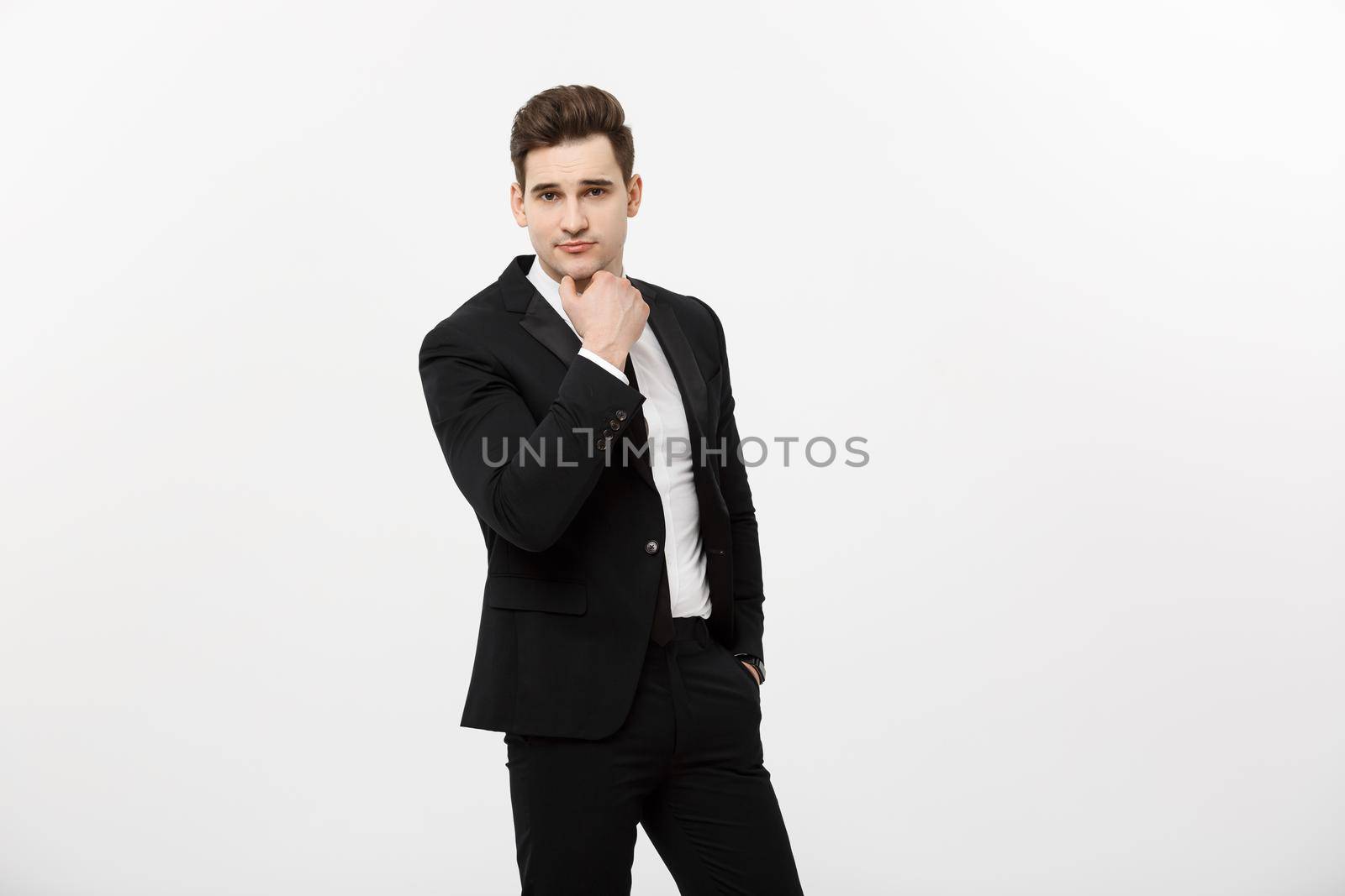 Young handsome man in black suit and glasses looking at copy-space smiling,thinking or dreaming isolated over white background.