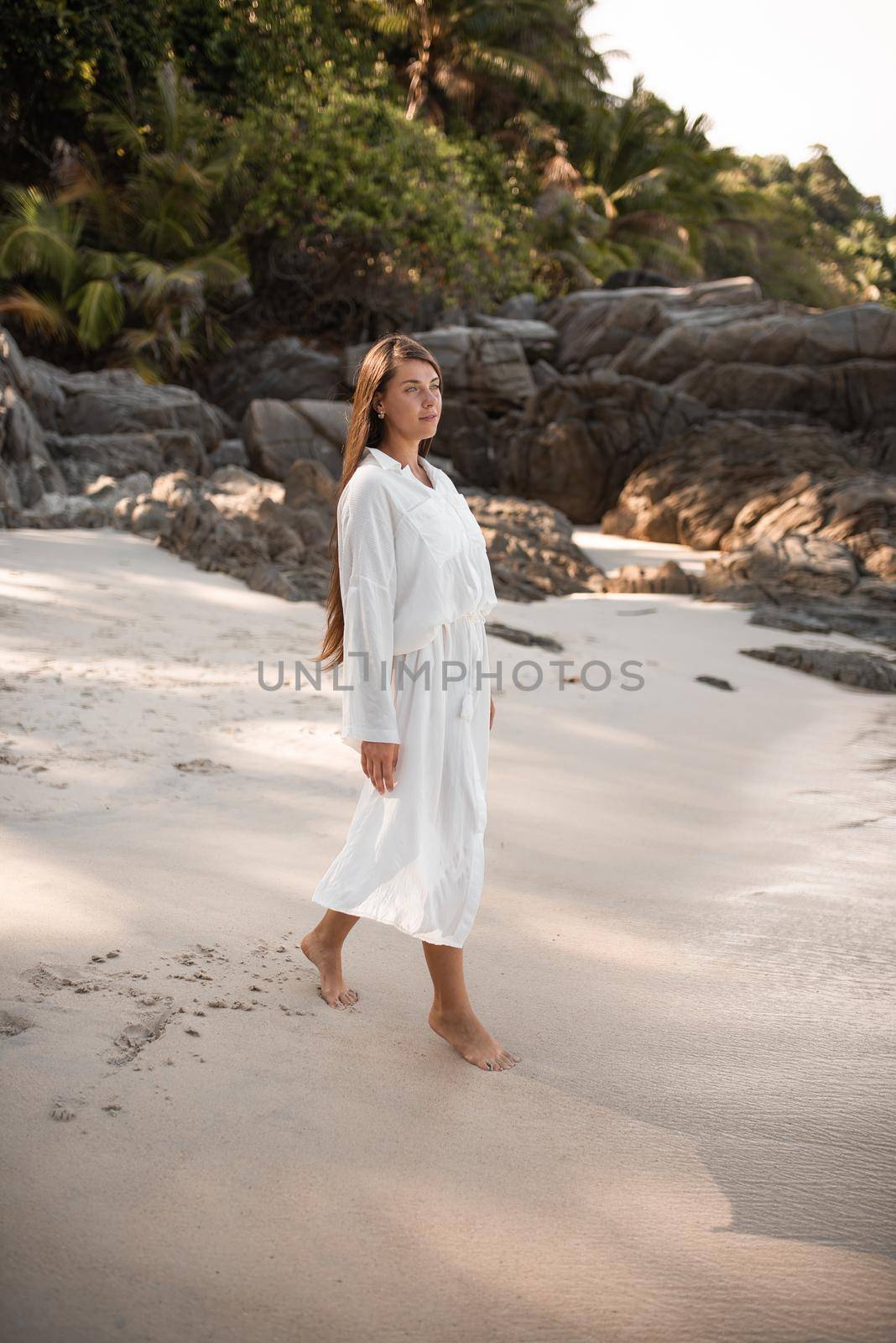 european young tan women have rest and run on white sand beach. long black chestnut hair . white cotton clothes. boho style dress.Thailand. Aquamarine crystal sea