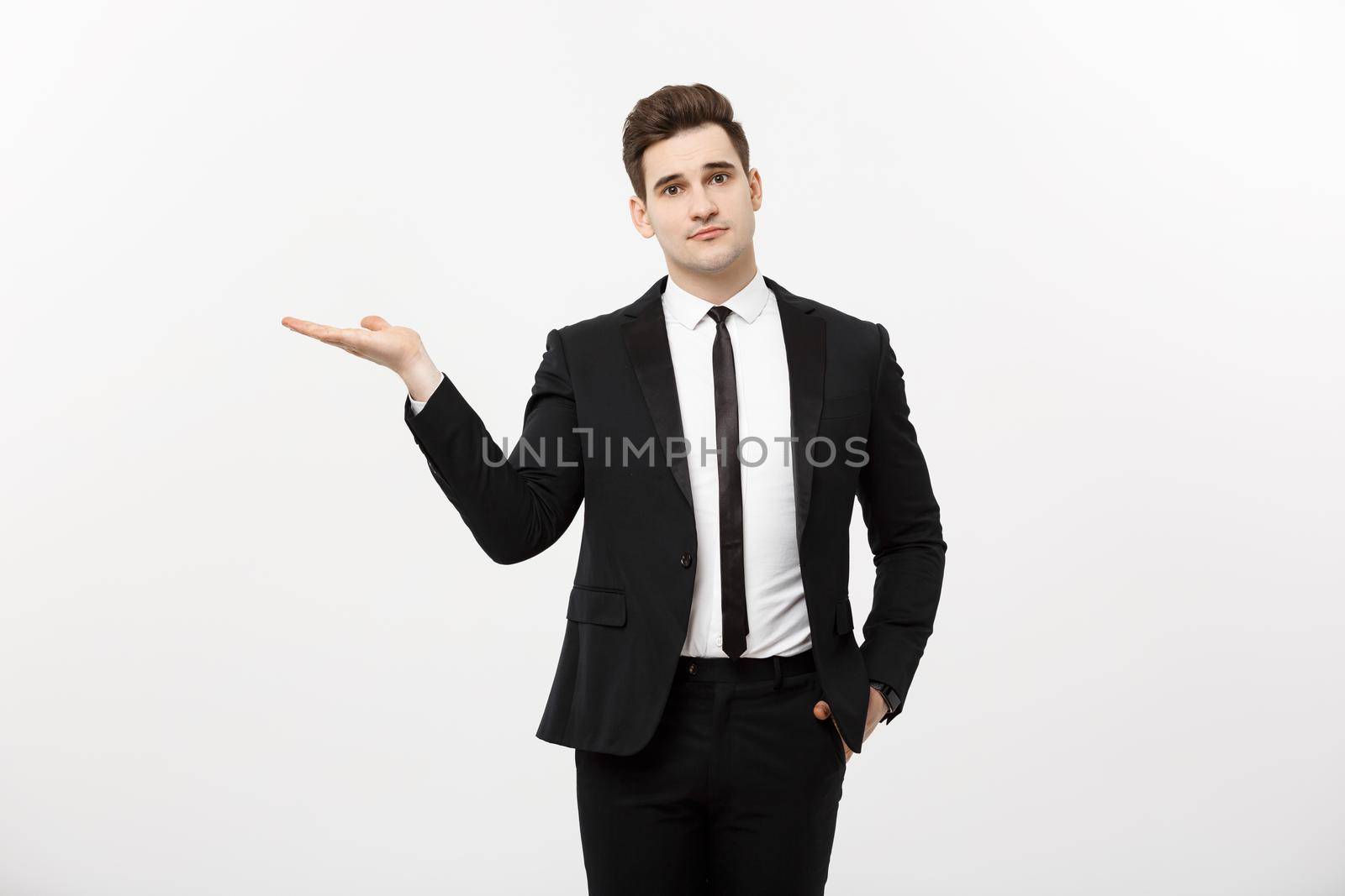 Business Concept: Attractive handsome business man shows hand on side. Copy space on white background.