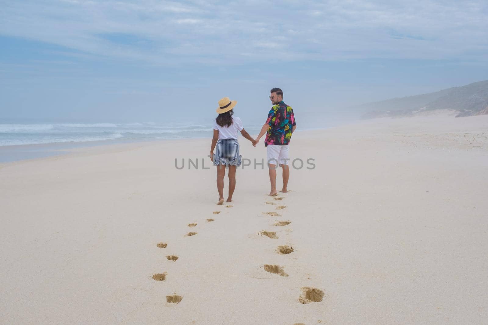 Man and woman walking at the beach De Hoop Nature reserve South Africa Western Cape, beach of south africa with the white dunes at the de hoop nature reserve which is part of the garden route by fokkebok