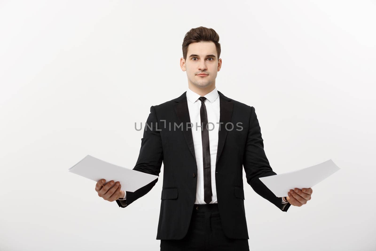 Business Concept: Attentive handsome businessman working comparing paper report. Isolated over white grey background