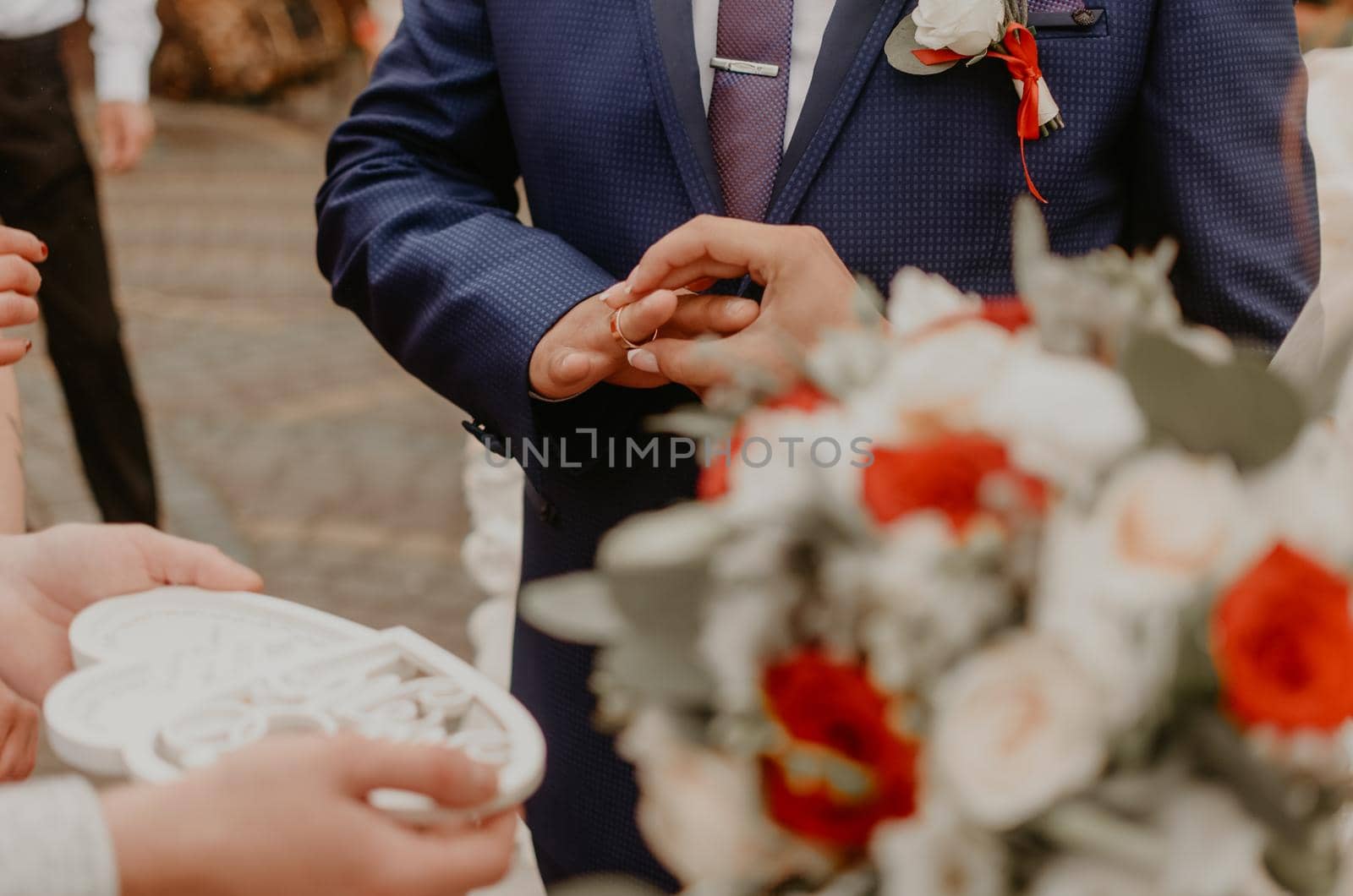 man puts a ring on woman ring finger as a sign of his love at a wedding by AndriiDrachuk