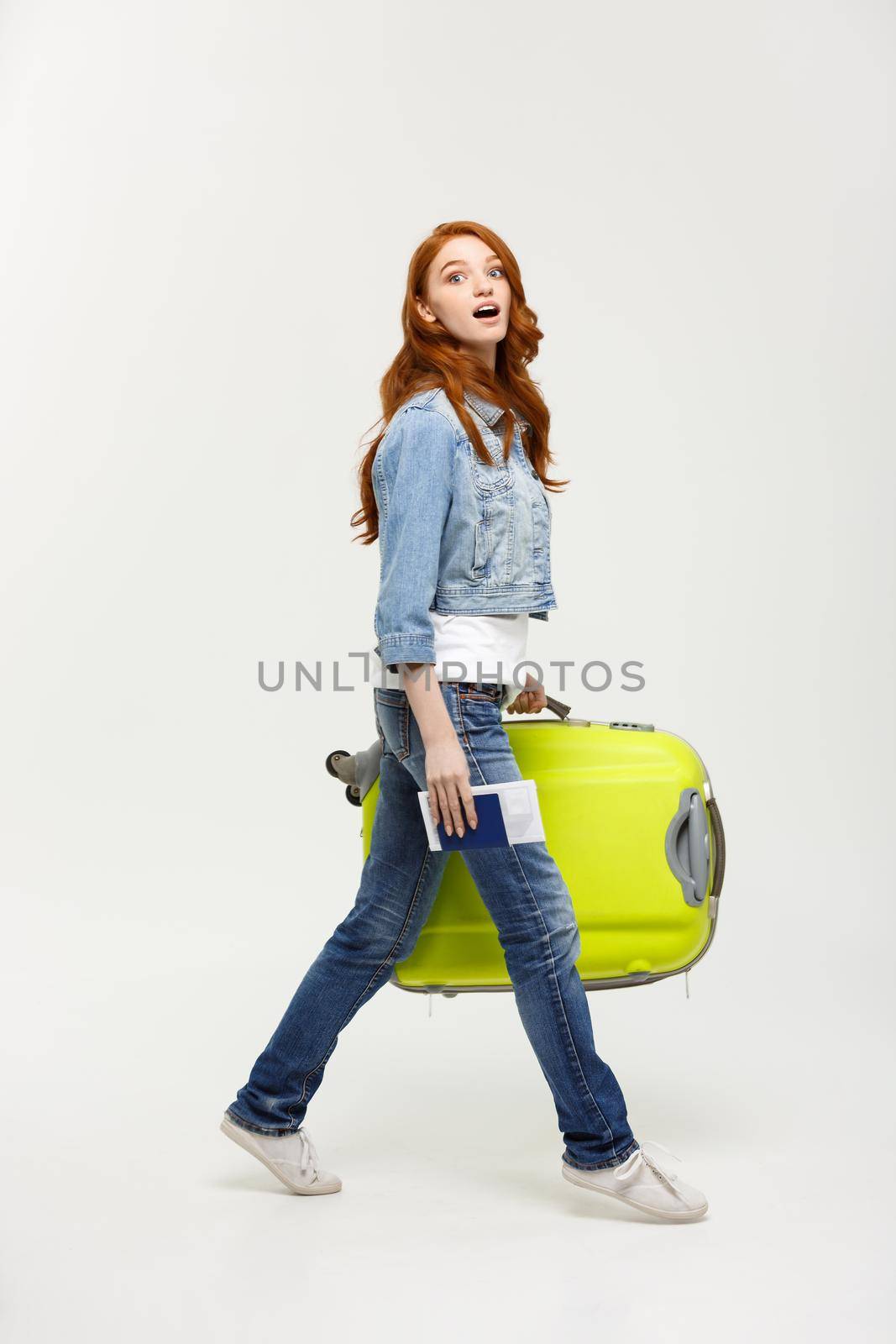 Travel Concept: Young Caucasian Woman traveler with suitcase isolated on white background