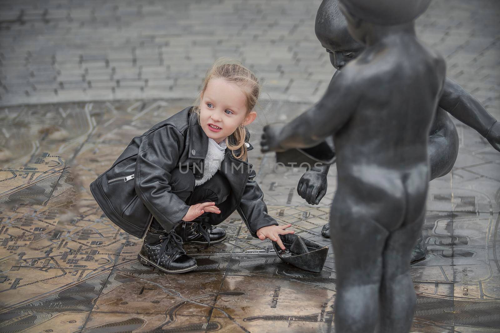 little girl is playing in the city square