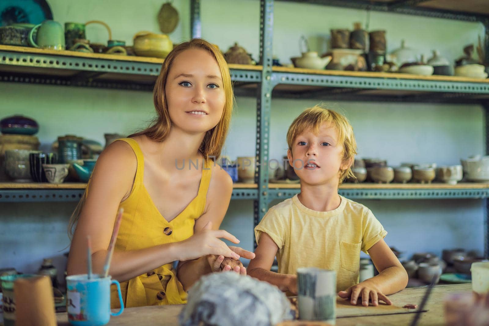 mother and son doing ceramic pot in pottery workshop.