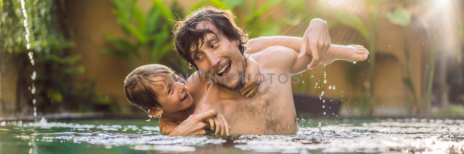 Dad and son have fun in the pool. BANNER, LONG FORMAT