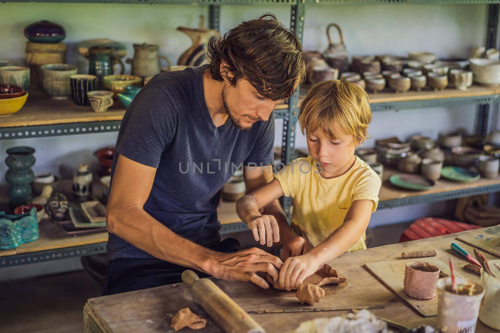 Father and son doing ceramic pot in pottery workshop.