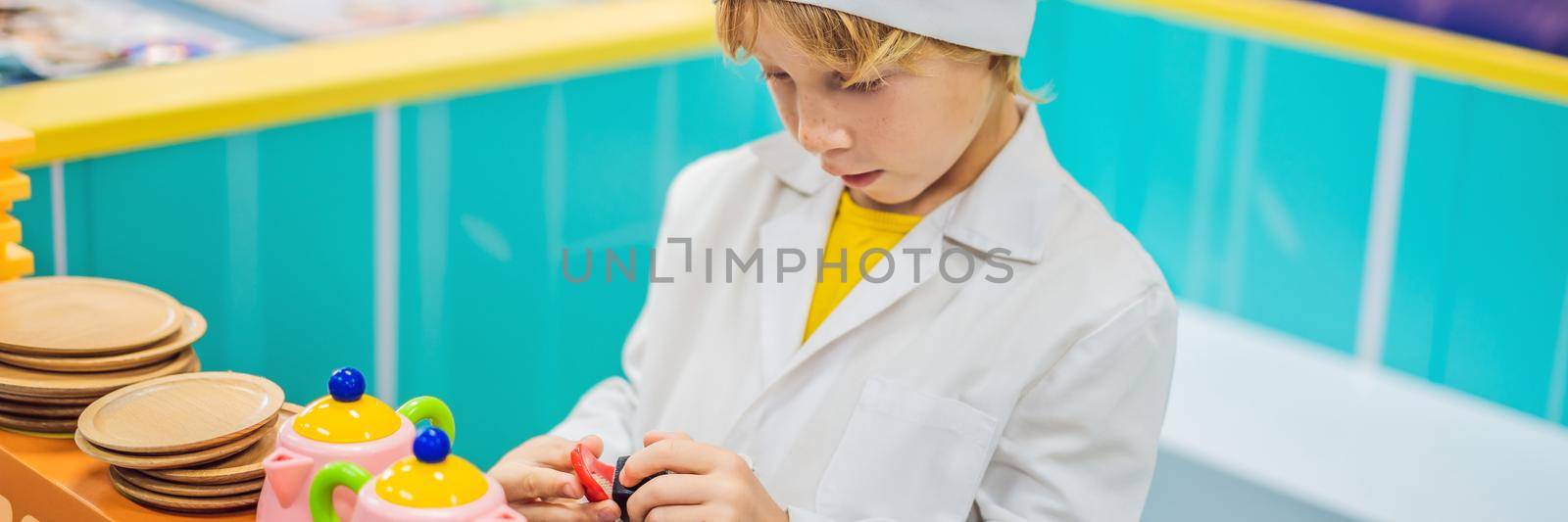 Boy plays the game as if he were a cook in a children's kitchen. BANNER, LONG FORMAT