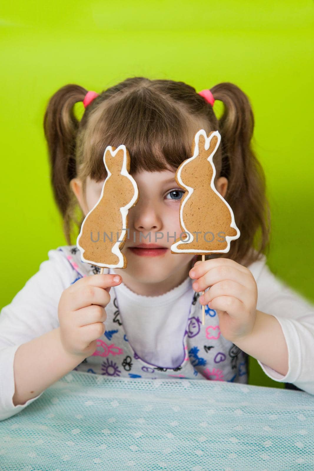 Beautiful girl holds gingerbread cookies in the form of a rabbit. Easter gingerbread cookie