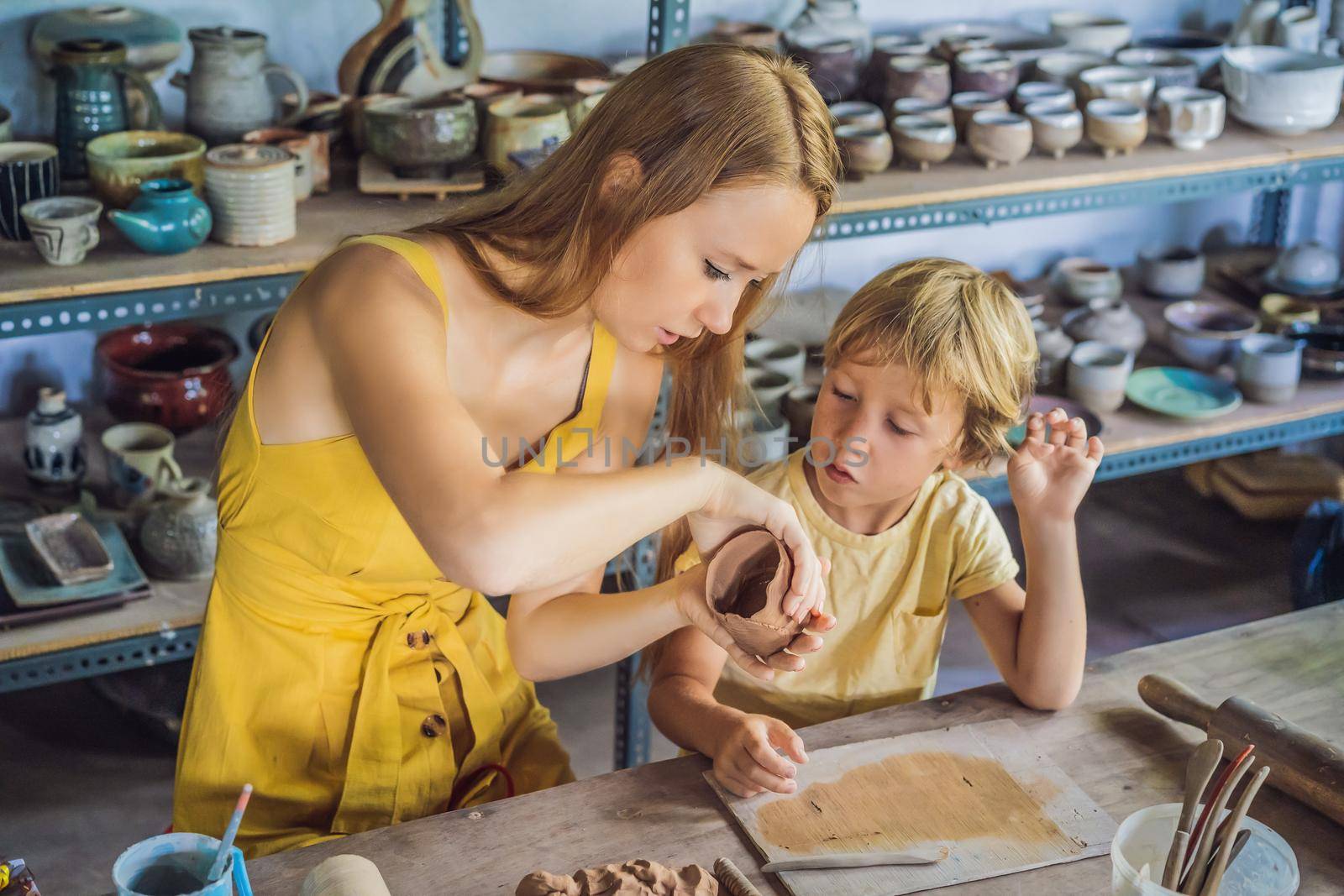 mother and son doing ceramic pot in pottery workshop.