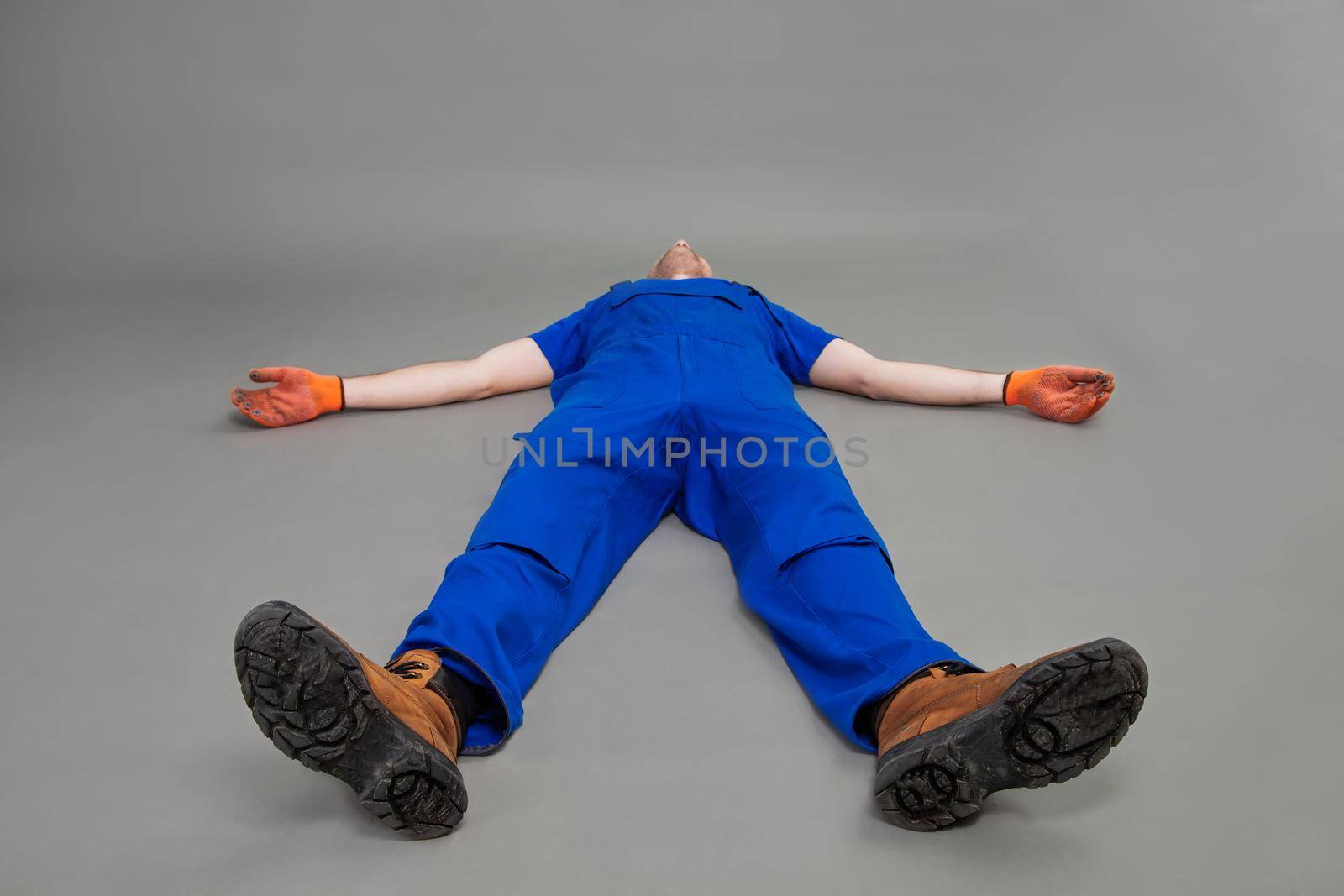 The worker lies on his back, legs forward. Exhausted or dead man was lying on the floor. The installer is swooning on the floor.