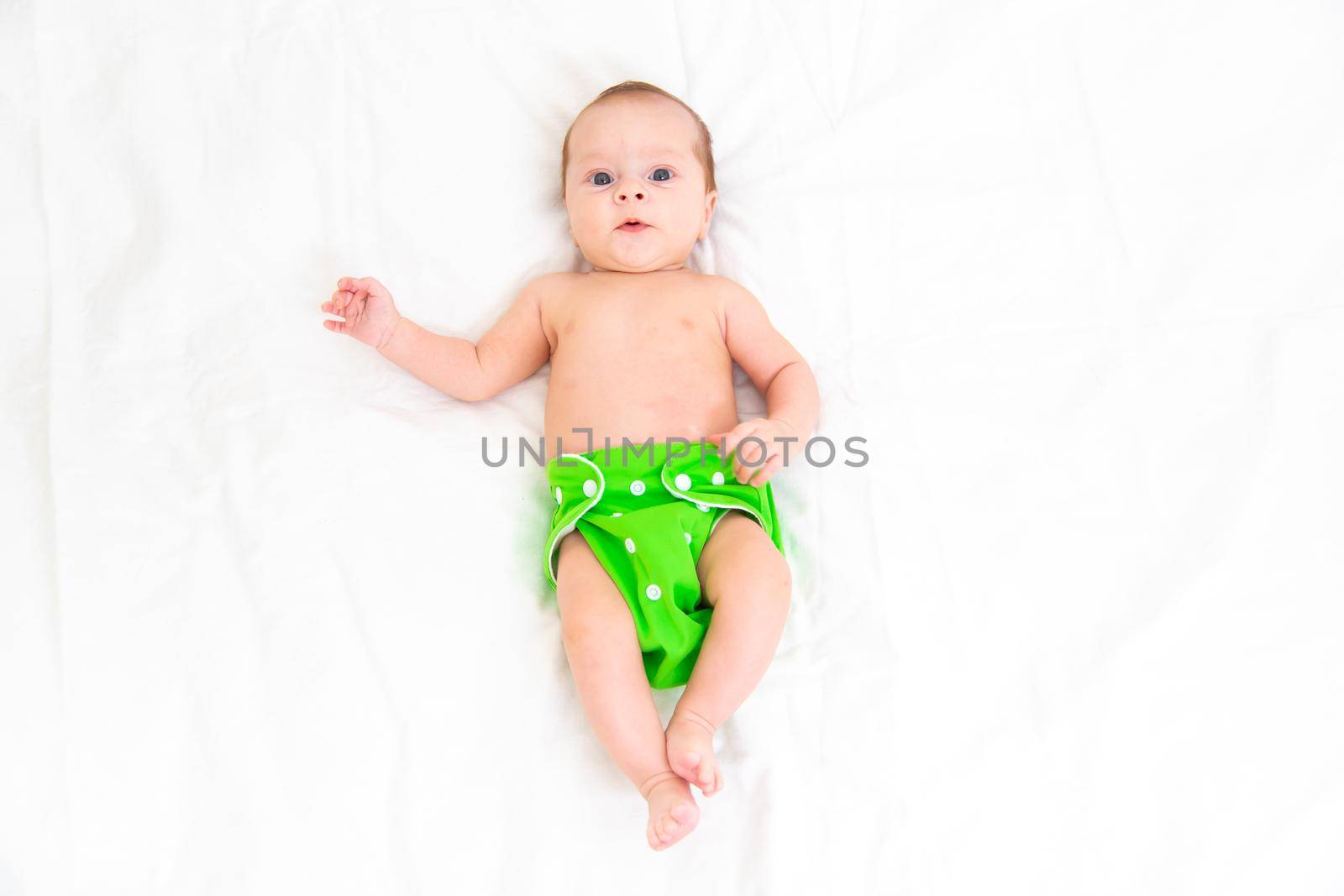 Reusable diaper on the baby copy space . An article about reusable diapers. Saving on diapers. Concern for the environment. Eco-products. Breathable diapers with buttons. High quality photo