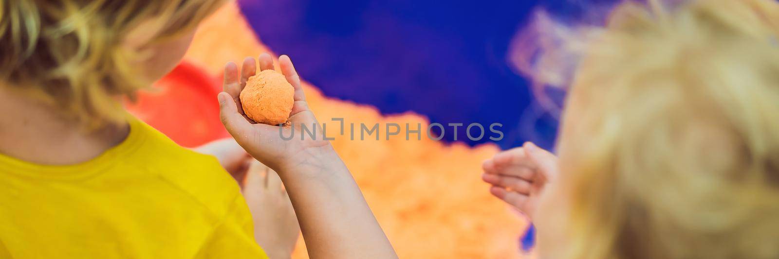 Boy and girl play with kinetic sand. BANNER, LONG FORMAT