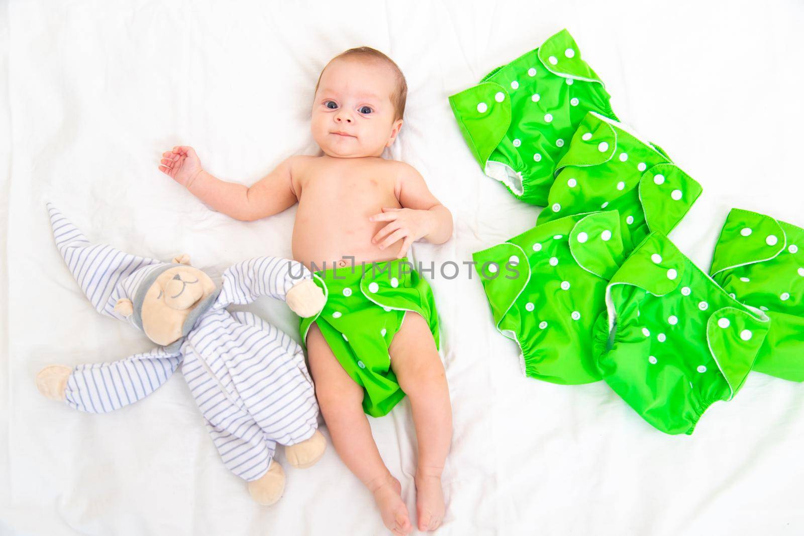 Reusable diaper on the baby copy space . An article about reusable diapers. Saving on diapers. Concern for the environment. Eco-products. Breathable diapers with buttons. High quality photo